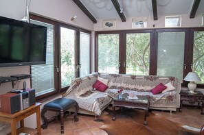 A living room with a sofa, a television, a table, and a bench. - House With Pool in Split Near the Beach (Split)
