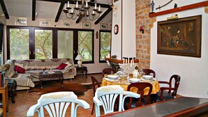 Un comedor con una mesa dispuesta para cuatro personas, un sofá y una araña.