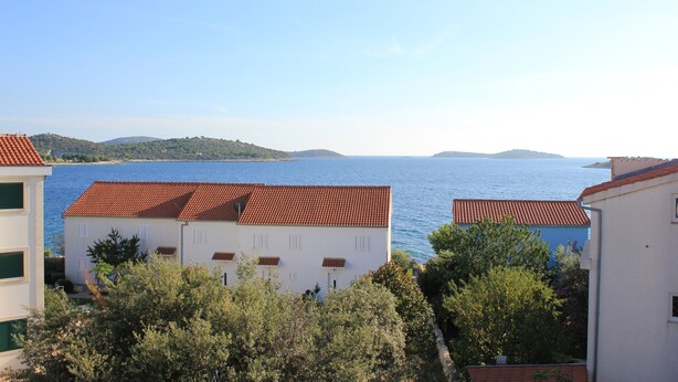 Blick auf die Küste mit Gebäuden und blauem Meer.