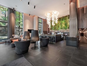 Um interior moderno com área de bar, assentos e grandes janelas.