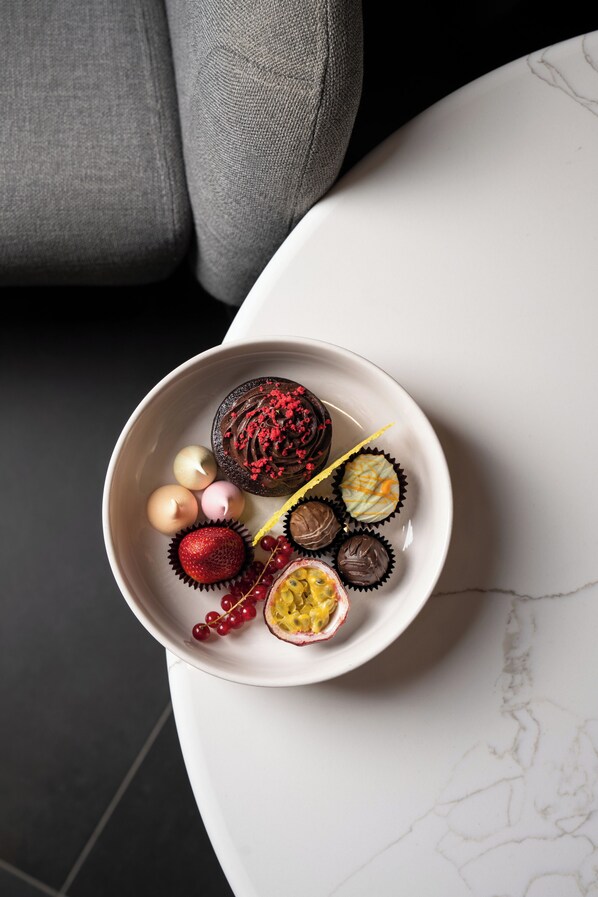 A bowl of assorted chocolates and fruits on a white table. - Mövenpick Hotel Tallinn (Tallinn)