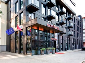 A modern hotel with a prominent 'Mövenpick' sign, large windows, and flags. - Mövenpick Hotel Tallinn (Tallinn)