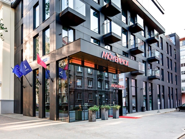 A modern hotel with a prominent 'Mövenpick' sign, large windows, and flags. - Mövenpick Hotel Tallinn (Tallinn)