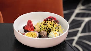 A bowl of assorted desserts on a table in a room with a modern design.