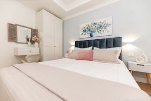 A bedroom with a bed, bedside tables, a dresser, a mirror, and a painting on the wall. - Apartment With Amazing sea View (Trogir)
