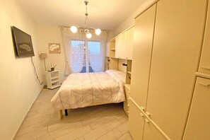Cozy retreat with a bed, wardrobe, and bedside table.