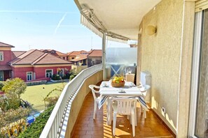 Enjoy dining or socializing on this balcony with a serene view of the surrounding houses.