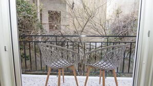 Two wicker chairs with wooden legs on a balcony with a metal railing. - Contemporary Design In Central Athens (Athens)