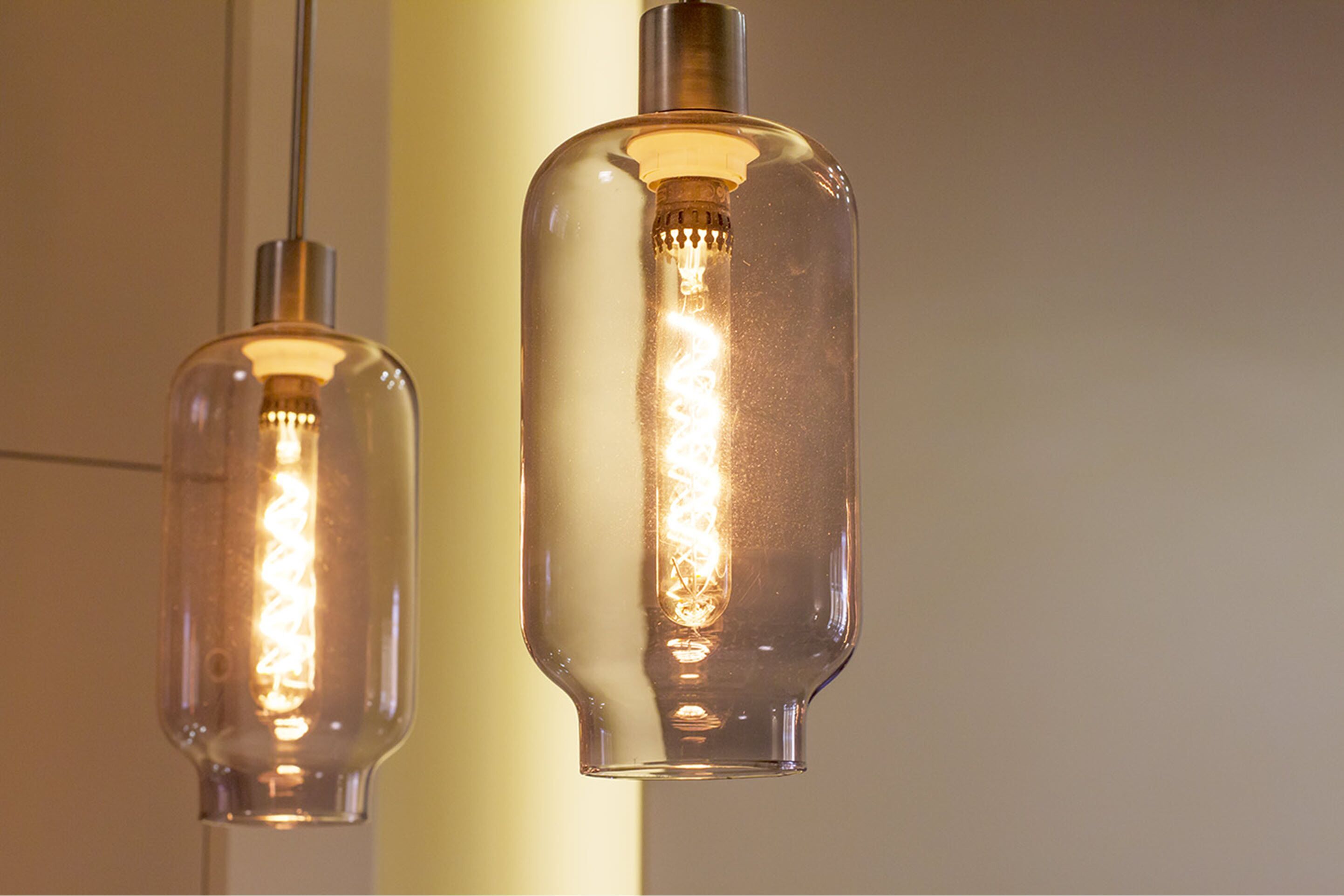 Two pendant lights with a clear glass enclosure and a visible filament bulb inside.