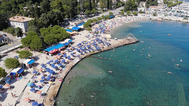 A coastal area with a beach, clear water, and a pier. - Luxurious Villa in Ružići Croatia With Private Pool and Garden (Matulji)