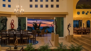 A spacious lobby with a view of the sunset over the ocean, a chandelier, and modern art sculptures. - Truly one of the Finest Villa for Rent in Puerto Vallarta (Puerto Vallarta)