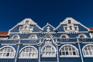 Fachada del Hotel King Edward con arquitectura clásica, que incluye ventanas arqueadas y molduras decorativas.