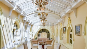 A spacious room with a high ceiling and a glass roof, featuring elegant furniture and a chandelier. - King Edward Hotel (Port Elizabeth)