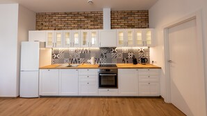 Eine moderne Küche mit weißen Schränken, einer Holz Arbeitsplatte und einer gefliesten Spritzschutzwand.