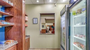 Una cocina con armarios de madera, un refrigerador y piso de baldosas.