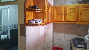 A kitchen with wooden cabinets, a gas stove, and a sink. - Surfapartment Taghazout Nr 6 (Taghazout)