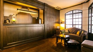 A lobby with a reception desk, a sofa, a coffee table, and a large window. - Your Private Oasis Stylish 2br With Spacious Living Room and Pool Access (Bangkok)