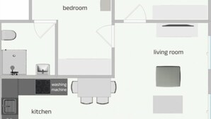 Une chambre avec un lit, une salle de bain, une cuisine équipée d’un lave-linge et un salon avec un canapé.