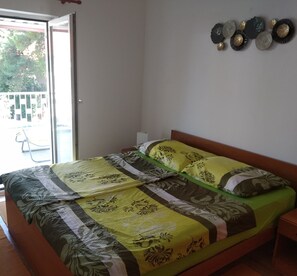 A double bed with floral bedding, a wooden headboard, and a nightstand with a lamp. - Great Location in Biograd, Large Terrace and 200m to the Beach! 2 Guests (Biograd na Moru)