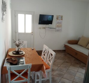 A dining area with a table, chairs, a television, and a calendar on the wall. - Great Location in Biograd, Large Terrace and 200m to the Beach! 2 Guests (Biograd na Moru)