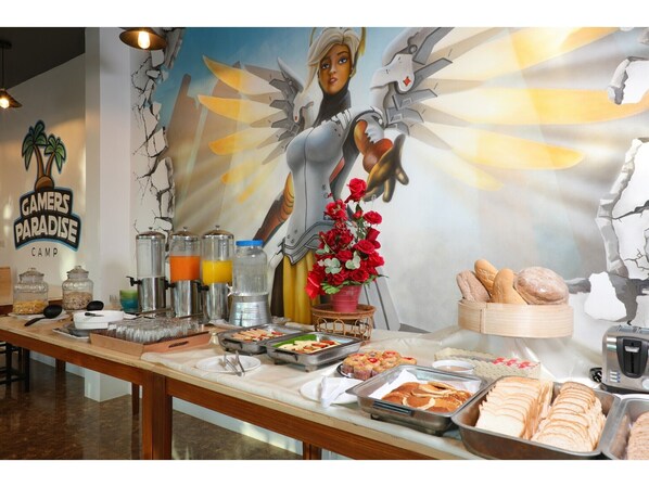 A buffet table with various food items and a mural in the background.