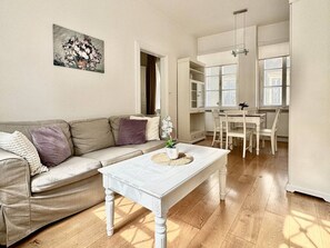 A living room with a sofa, coffee table, and a painting on the wall.