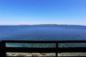 A clear view of the ocean from a window with a wooden frame.