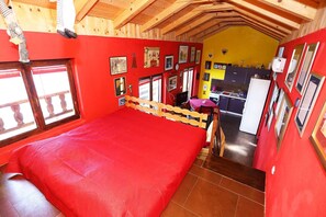 A room with a bed, a kitchenette, and a dining area.