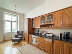 A kitchen with wooden cabinets, a black countertop, and a grey chair. - The BEST place in Prague - Old Town (Prague 1)