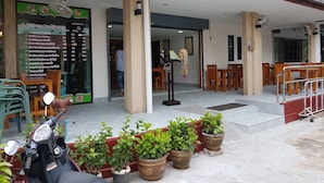 A hotel entrance with a reception desk, indoor seating area, and potted plants. - Welcome Inn Hotel Karon Beach (Karon)
