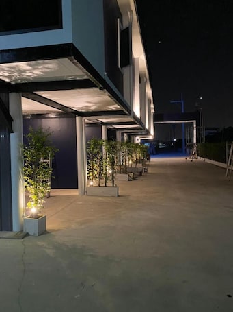 A modern building with a covered walkway and potted plants.