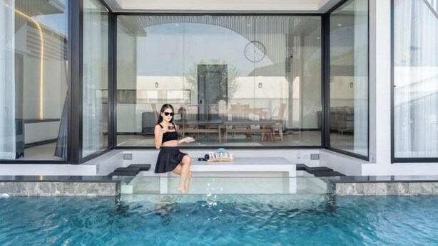 A modern poolside area with a glass enclosure, a ceiling fan, and a bench. - Skyline Resort (Bang Phli)