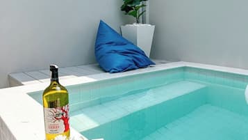 A swimming pool with a bottle of wine and flowers on the edge.