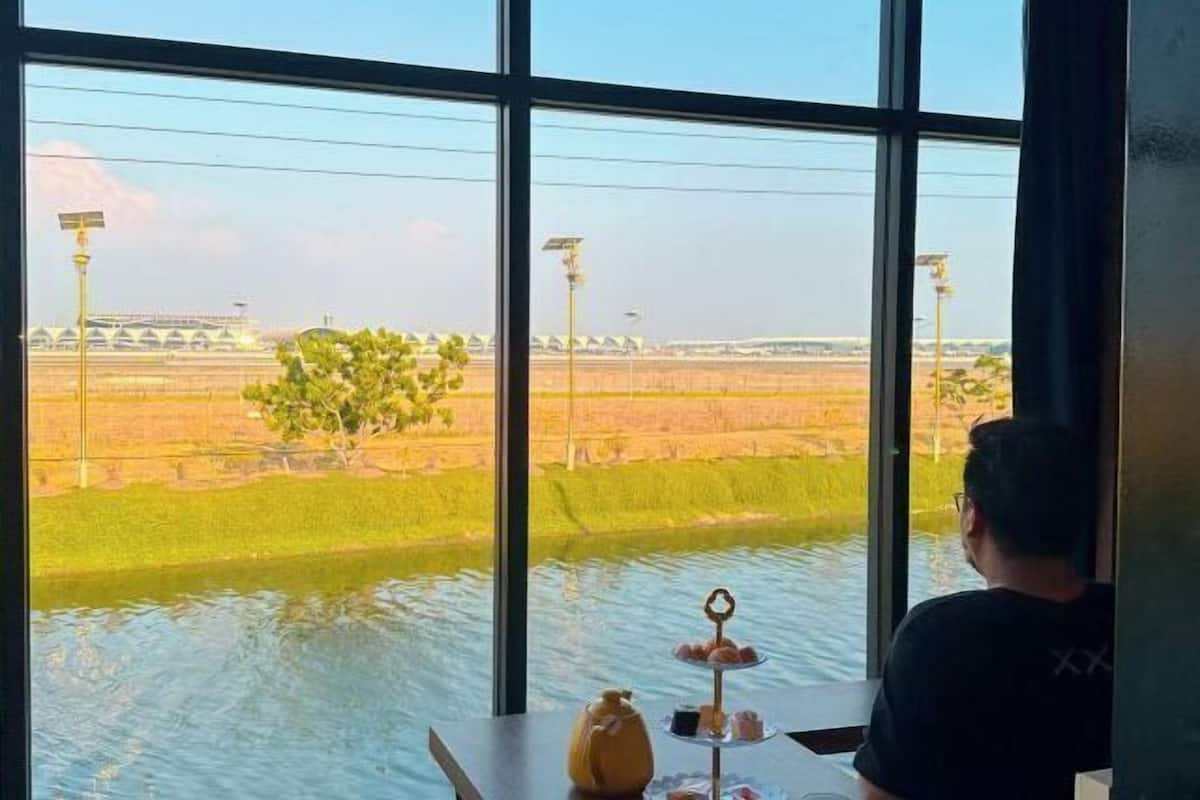 A room with a large window overlooking a rice field.