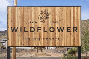 A wooden signboard for Wildflower Zion Resort with the establishment year 2020.