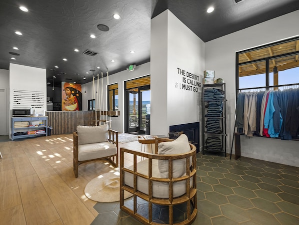 A modern interior with a seating area, a clothing rack, and a wall with motivational text. - Zion Wildflower Resort, WorldHotels Backdrop (Virgin)