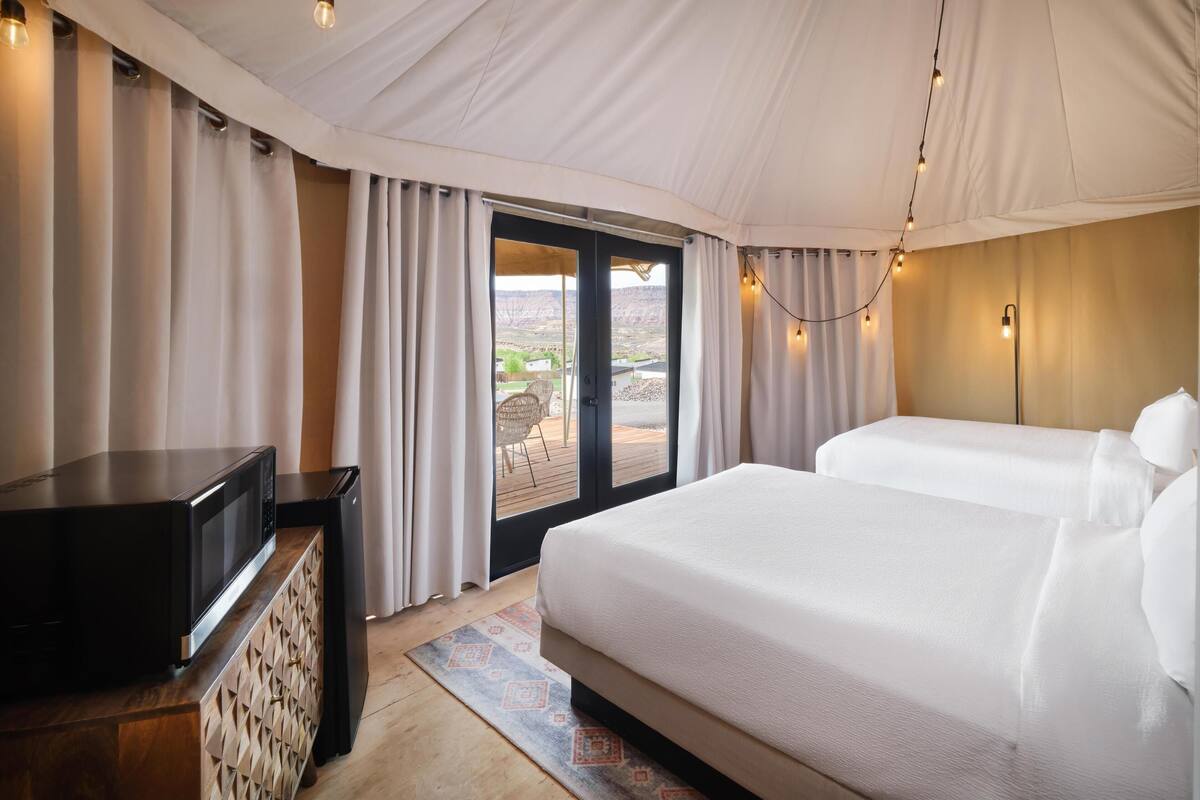 Quarto com uma cama, televisão e vista para o exterior.