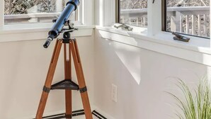A room with two windows, a telescope on a tripod, and a plant. - Family retreat: 5 min walk to Bayview Beach, sleeps 10 (Dennis)