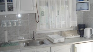 A kitchen with white cabinets, a stainless steel sink, a coffee maker, and a toaster. - New And Completely Renovated Apartment 5-1 (Marina)