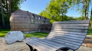 A wooden bench in a park with a rustic building in the background. - Iglu Camp Heidewald (Sassenberg)