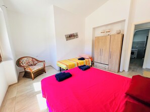 Une chambre à coucher avec un grand lit, une armoire en bois, une chaise et une petite table avec une lampe.