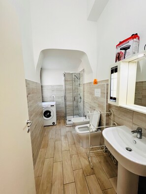Une petite salle de bain comprenant une douche, des toilettes et un lavabo.