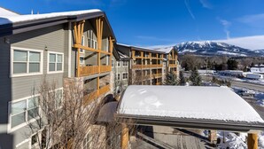 A multi-story building with a wooden facade and a snow-covered roof. - 2 Bedrooms | Mountain Views l AC (Fernie)