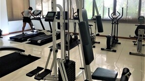 A gym with various exercise equipment, including treadmills, weight machines, and a bench. - Royal Hill Resort Pattaya Corner Condo With sea & Pool Views (Pattaya)
