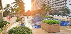 Relax by the pool surrounded by lush greenery and take in the stunning views of the surrounding architecture.