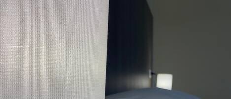 A lamp with a white shade on a wooden table.