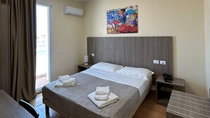 A hotel room with a large bed, a desk, a chair, a painting on the wall, and a window with curtains. - 55 Aira (Palermo)