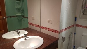 A bathroom with two sinks, a shower, and a toilet. - Jomtien Beach Condominium 5th Floor Modern Studio Apartment Pattaya (Pattaya)