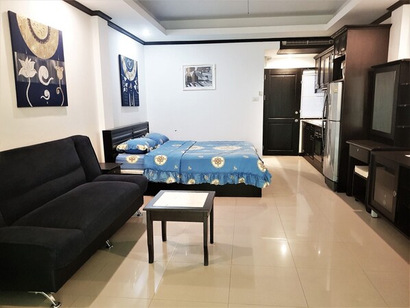 Cozy living space with a sofa, bed, and kitchenette, perfect for a compact retreat.