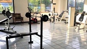 A gym with exercise equipment, large windows, and a tiled floor. - Angket Condominium Fully Furnished 14th Floor Studio Apartment (Pattaya)